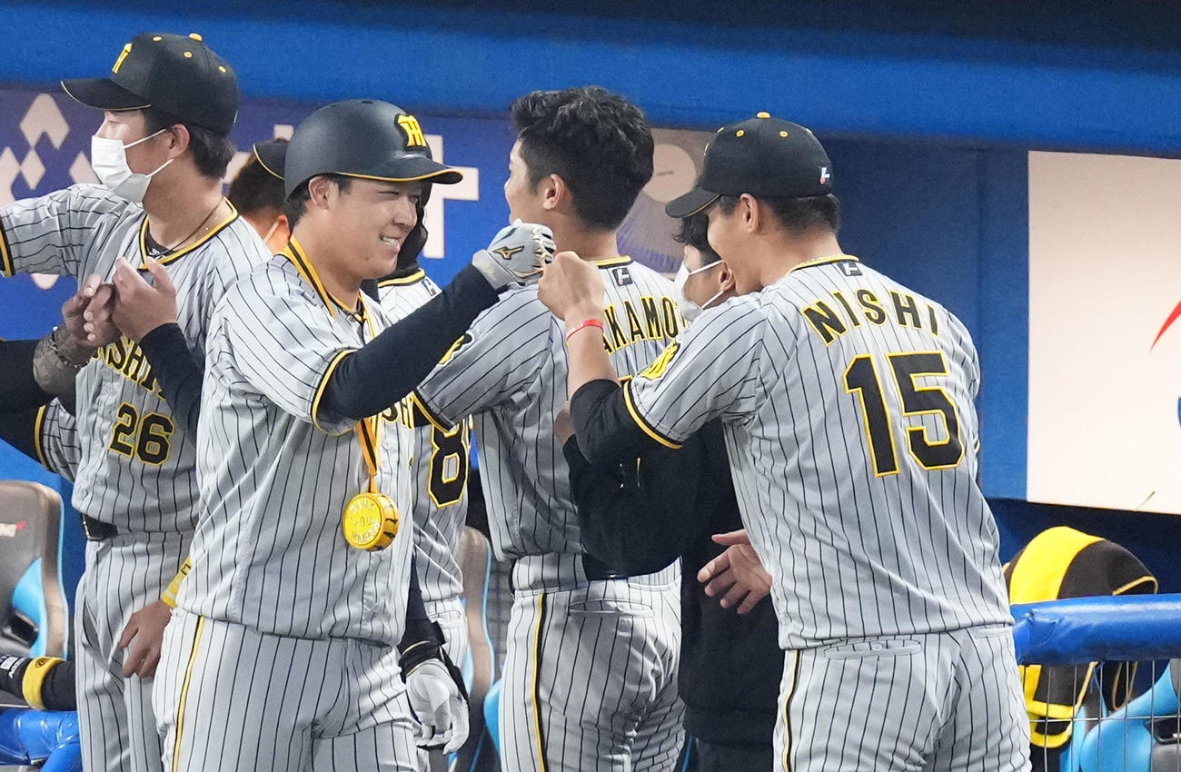 ヤクルト対阪神　3回表阪神2死一、三塁、左越えに3点本塁打を放ち、西純（右端）にタッチで迎えられる大山（撮影・菅敏）