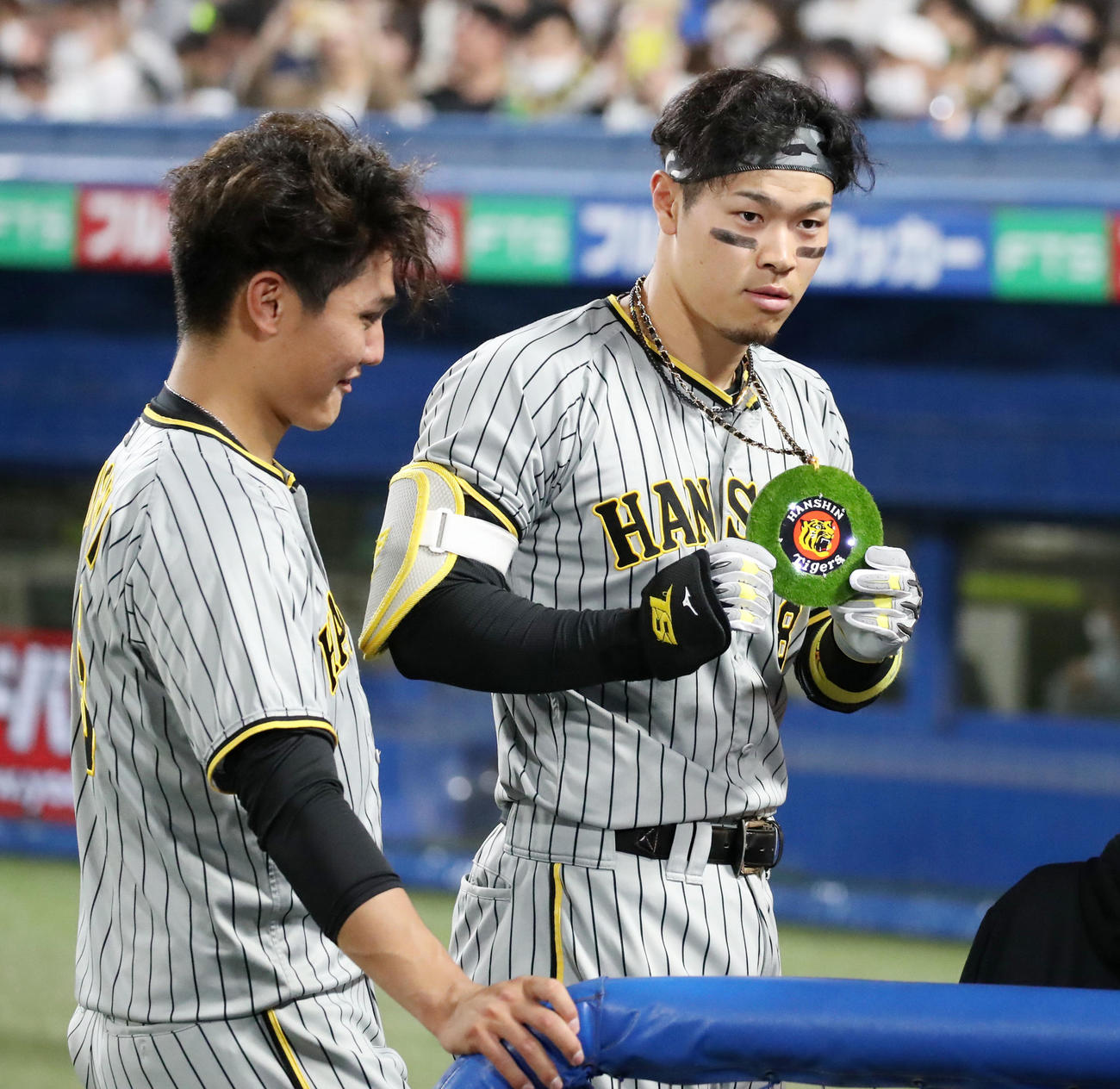 ヤクルト対阪神　6回表阪神無死、佐藤輝は中越え本塁打を放ち、かけていたメダルを見せる（撮影・加藤哉）