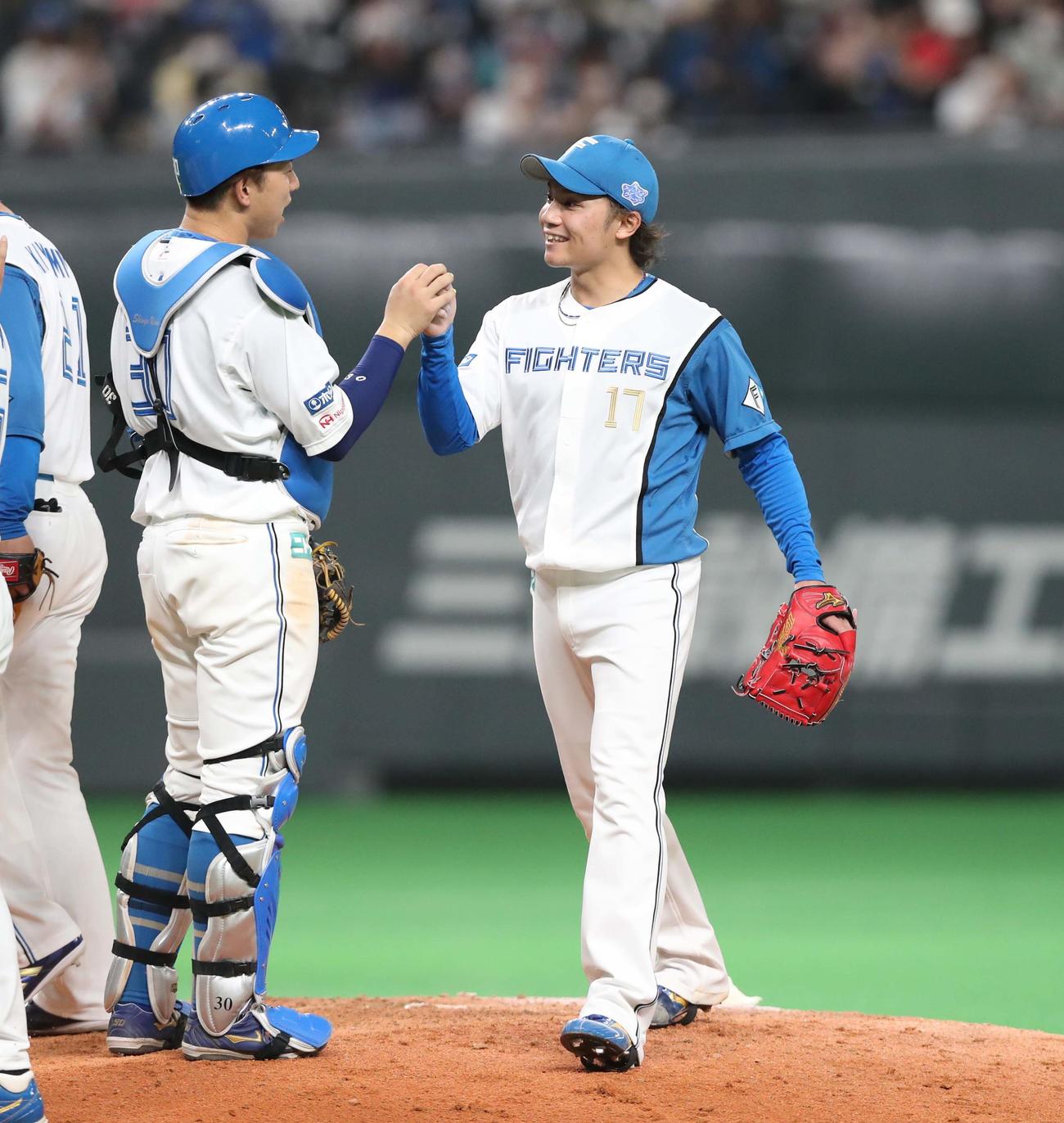 13日　日本ハム対ソフトバンク　試合後、宇佐見（左）とタッチする伊藤（撮影・黒川智章）