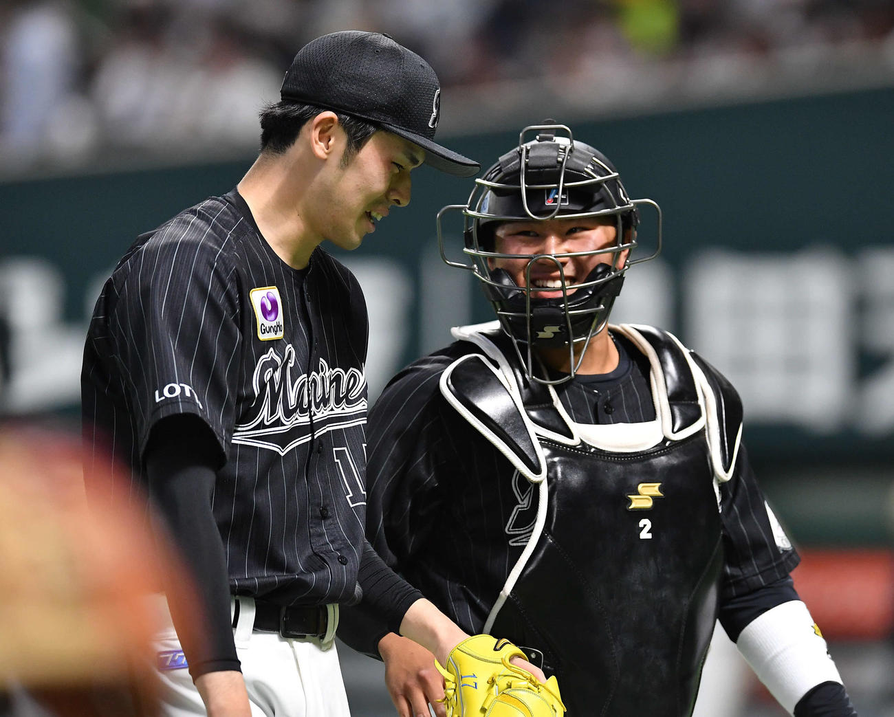 ソフトバンク対ロッテ　3回裏、3者連続三振を奪い、松川（右）と笑顔で話しながらベンチへ戻る佐々木朗（撮影・岩下翔太）