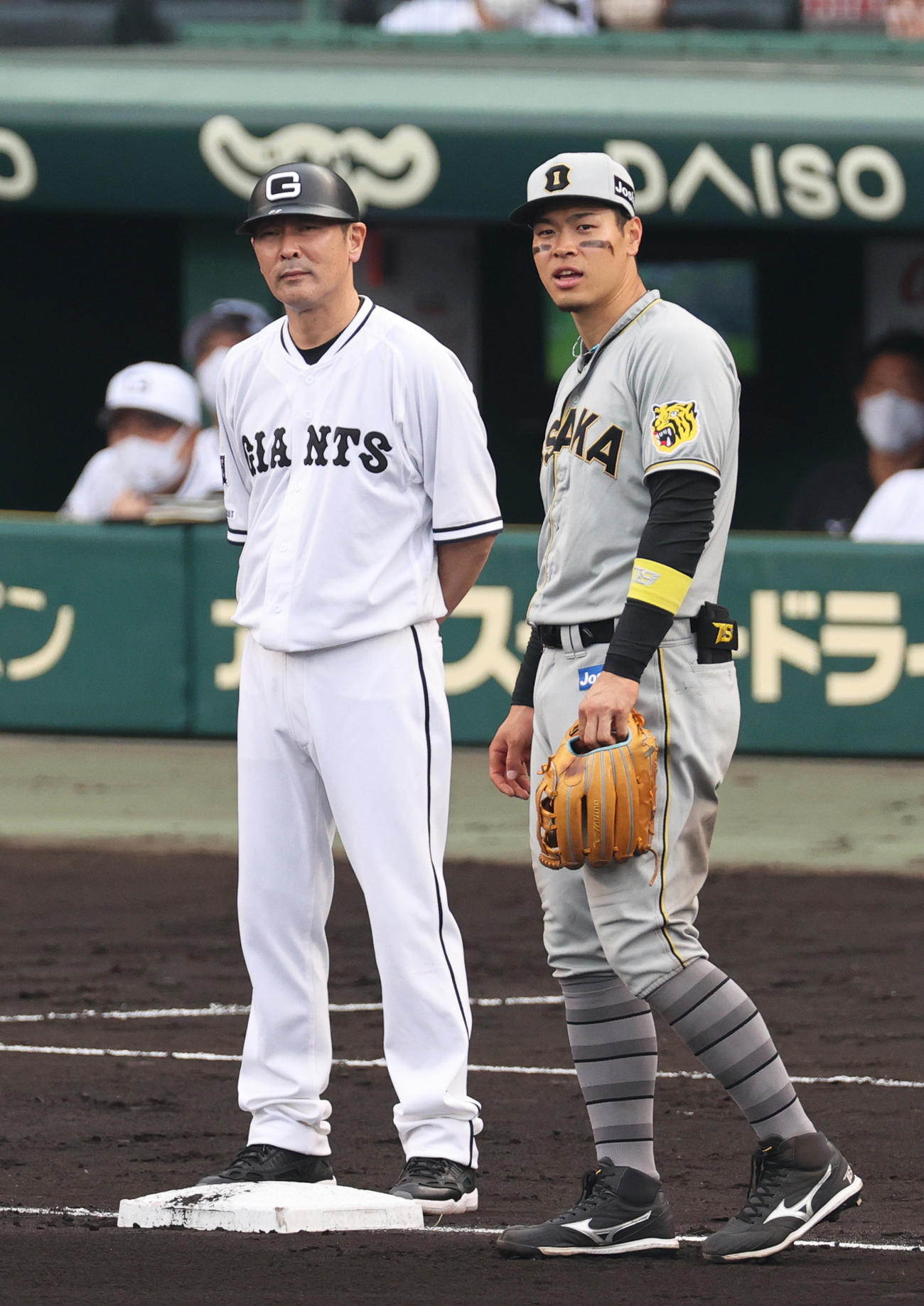 阪神対巨人　8回表巨人1死一塁、代走増田大の二盗アウトの「リクエスト」検証中に巨人元木ヘッドコーチ（左）と話す阪神佐藤輝（撮影・上山淳一）