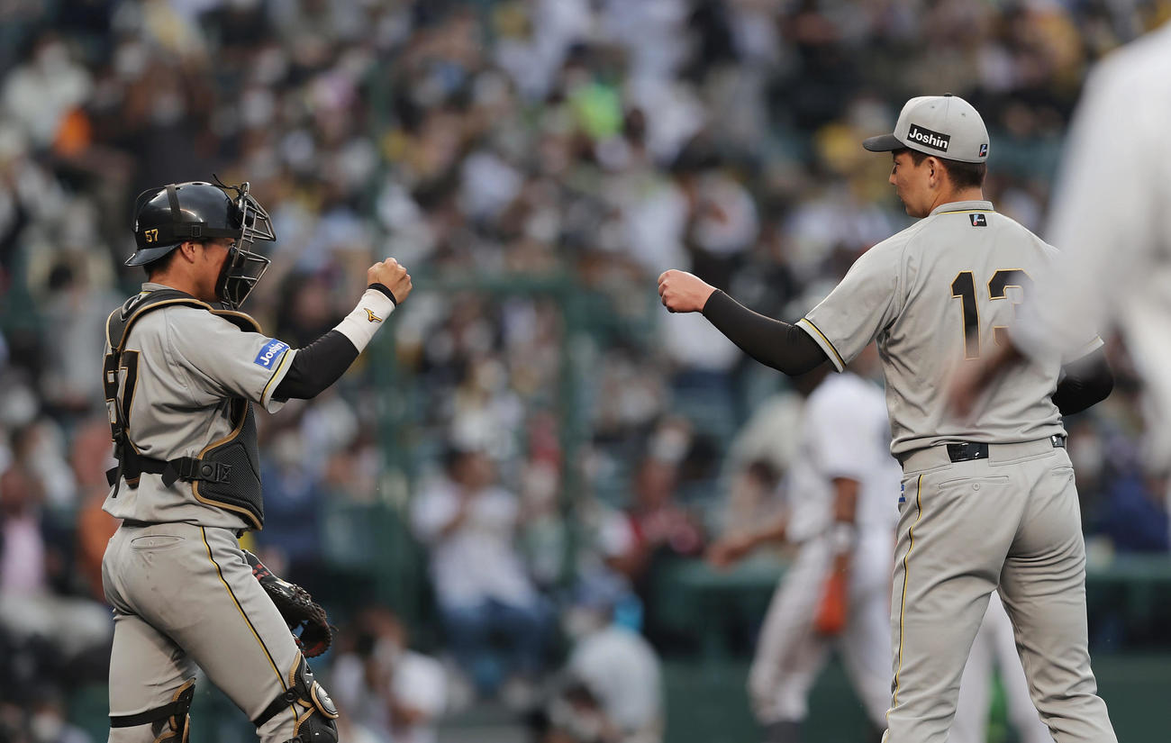 阪神対巨人　巨人に勝利し、グータッチを交わす阪神長坂（左）と岩崎（撮影・前田充）