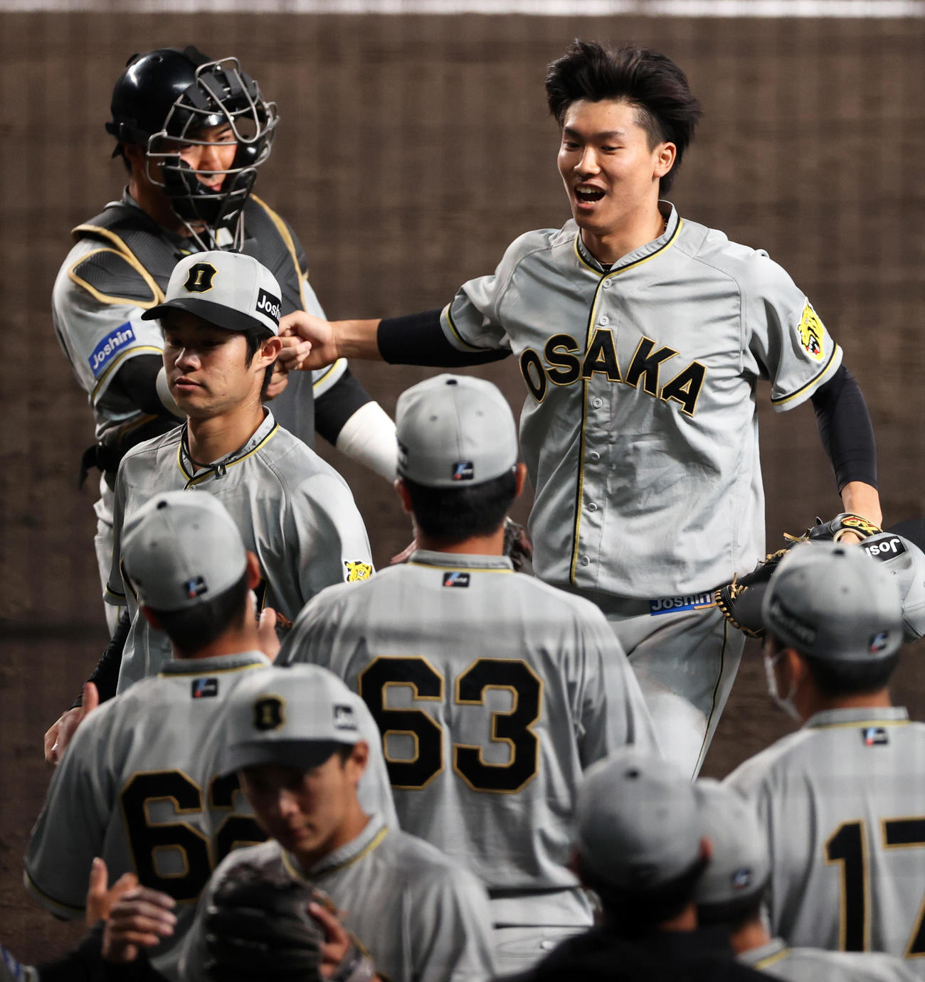 11回に登板の阪神湯浅（右上）は3者凡退に抑えナインの出迎えに笑顔を見せる（撮影・上山淳一）