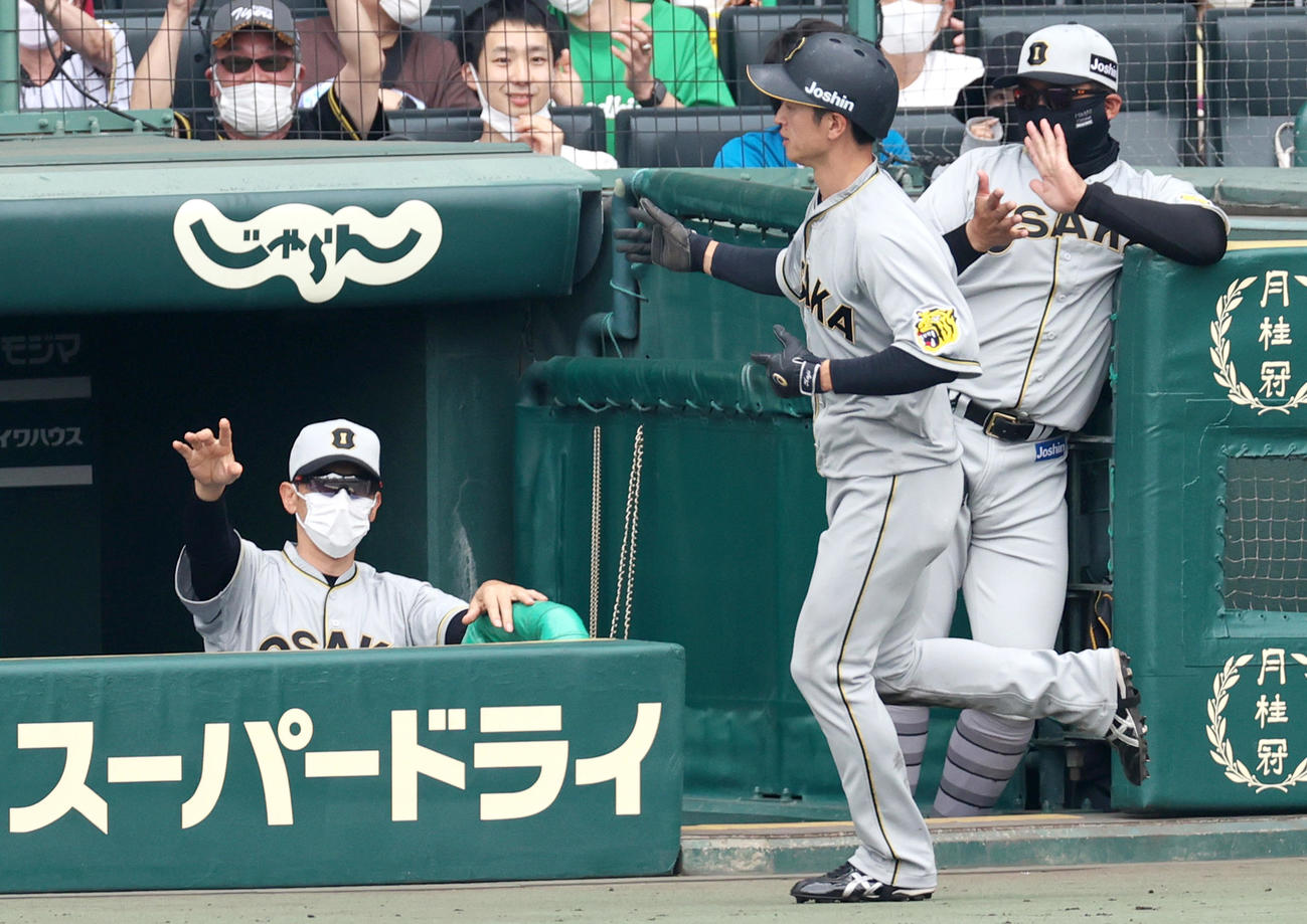 阪神対巨人　1回裏阪神1死二塁、矢野燿大監督（左）はマルテの中前適時打で生還の近本光司（手前）を出迎える（撮影・上山淳一）