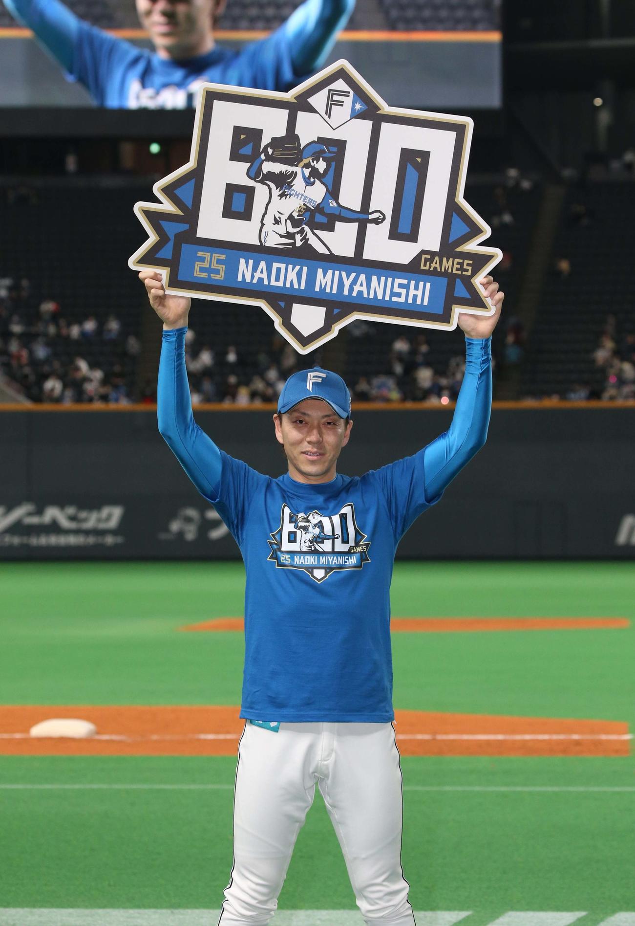 日本ハム対西武　通算800試合登板を達成し記念ボードを掲げる宮西（撮影・黒川智章）
