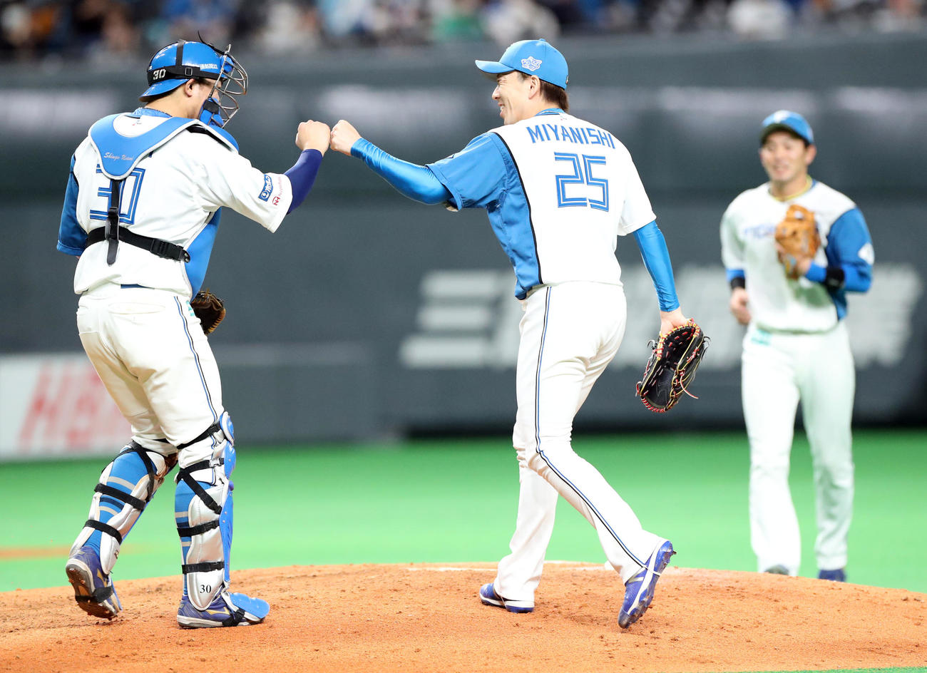 日本ハム対西武　9回表西武2死、山川を二飛に仕留め笑顔でタッチを交わす日本ハム宇佐見（左）と宮西（撮影・佐藤翔太）