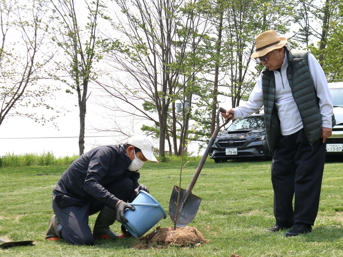栗の樹の苗に水やりする日本ハム栗山プロフェッサー（左）を見守る倉本氏（撮影・田中彩友美）