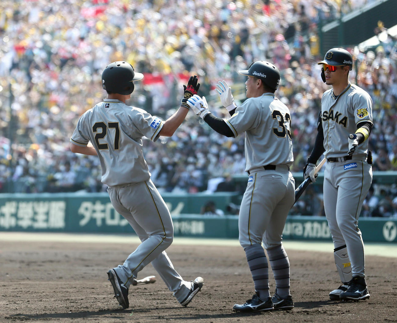 阪神対巨人　2回裏阪神2死満塁、二走伊藤将（左）は大山の左前適時打と相手守備のミスで一気に生還し出迎えを受ける（撮影・上山淳一）