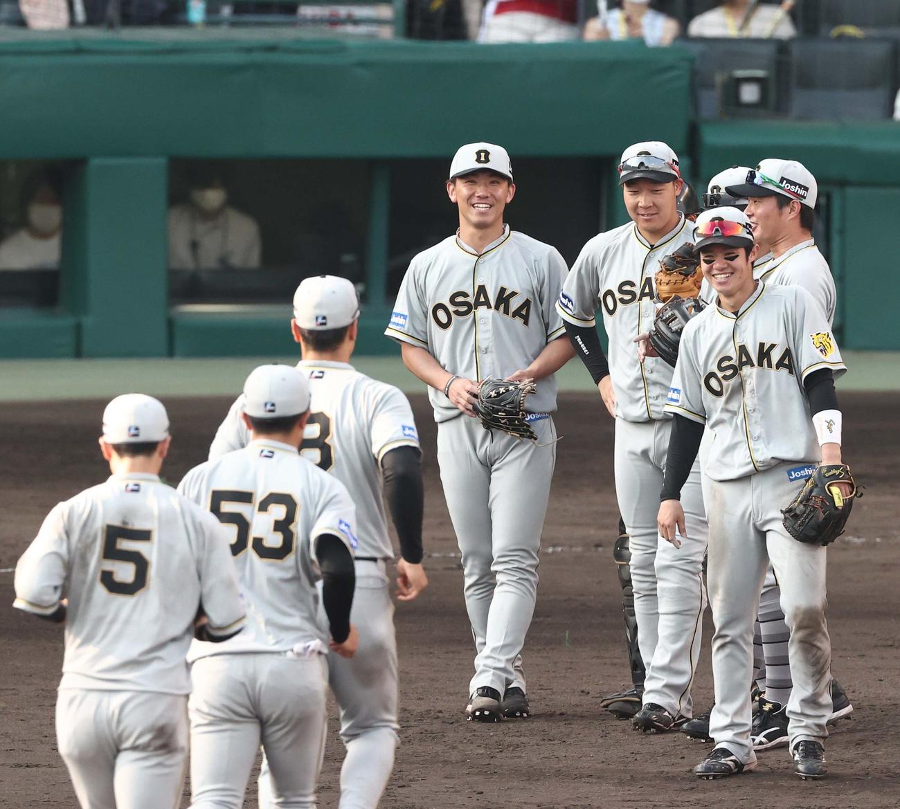 阪神対巨人　完封勝利した伊藤将（中央）は笑顔でナインを迎える（撮影・上田博志）