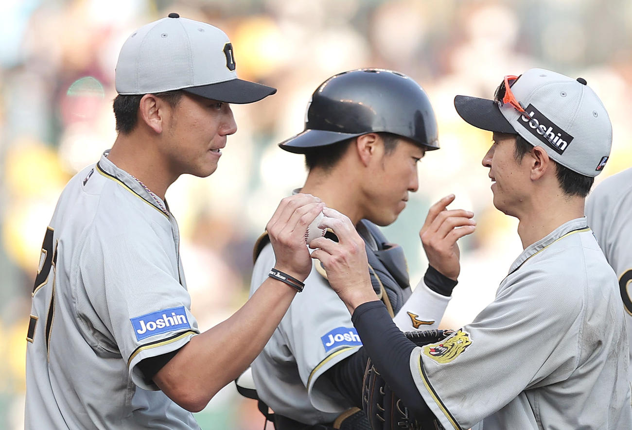完封勝利を挙げ、近本（右）から勝利球を受け取る伊藤将。中央は長坂（撮影・前田充）
