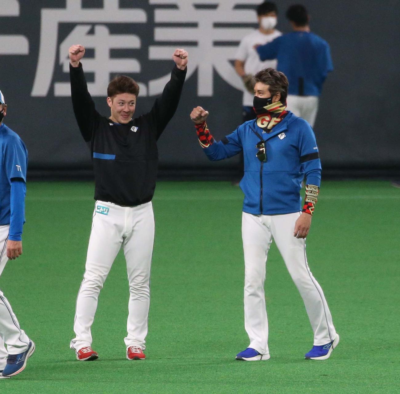 練習中、新庄監督（右）と話しガッツポーズする吉田輝星（2022年5月21日撮影）