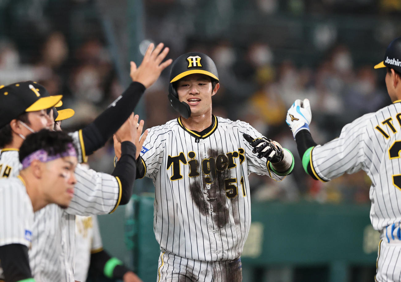 阪神対楽天　6回裏阪神2死二塁、中野（中央）は大山の中前適時打で先制生還しナインの出迎えに笑顔を見せる（撮影・上山淳一）