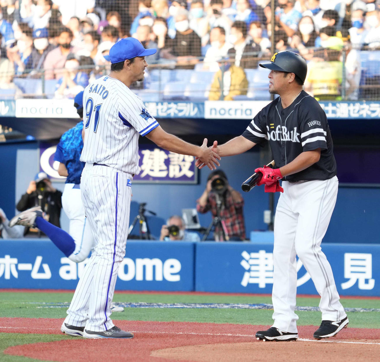 DeNA対ソフトバンク　試合前のセレモニーで直接対決し握手するDeNA斎藤チーフ投手コーチ（左）と元ソフトバンク松中氏（撮影・小沢裕）