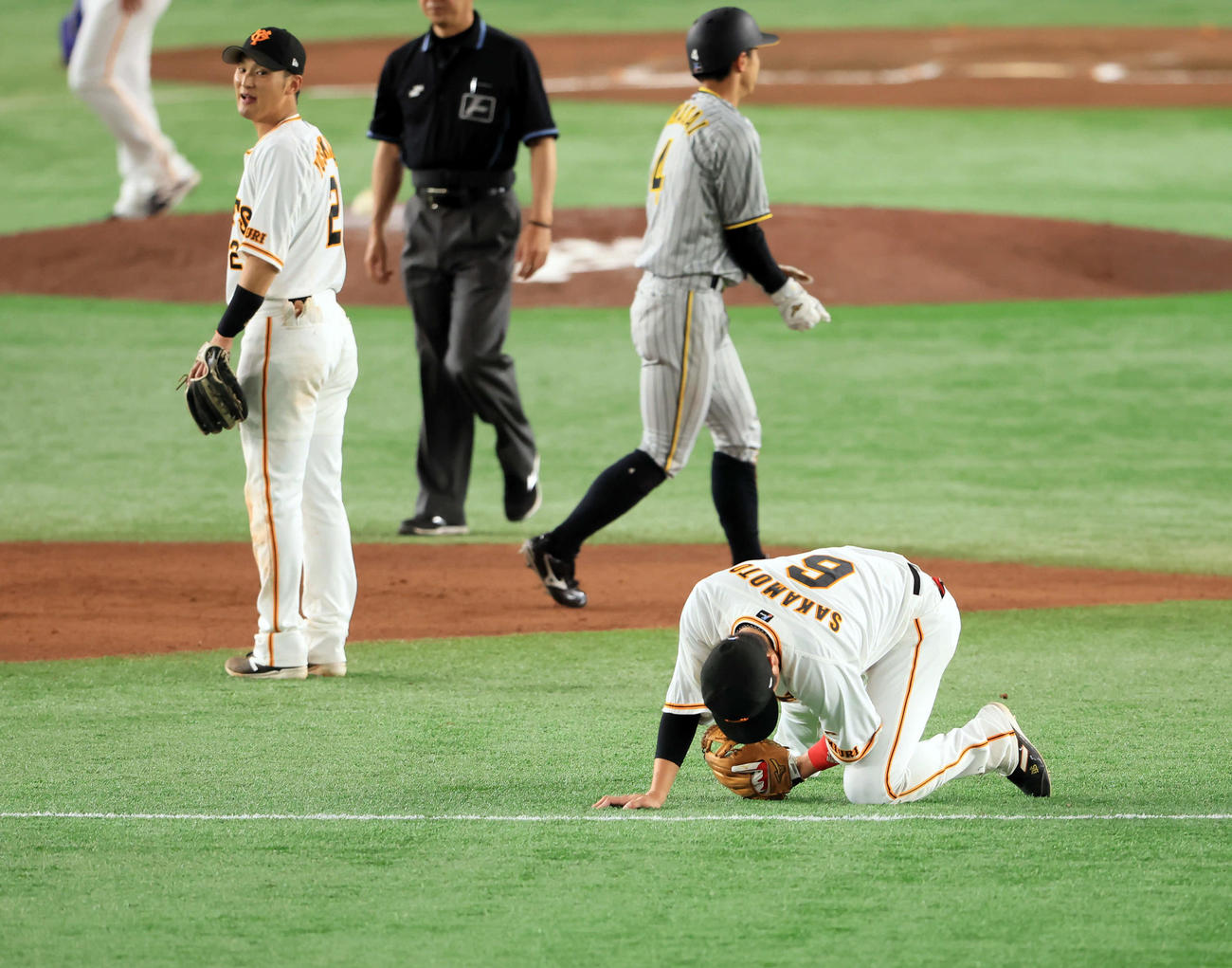 4月30日阪神戦の7回、遊ゴロを好捕した坂本勇人（右）は、痛そうにうずくまる