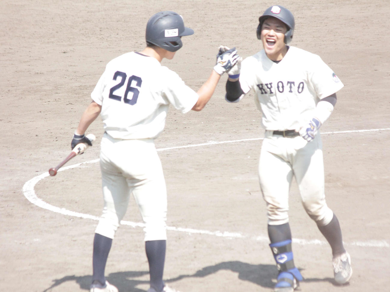 京大の愛沢祐亮捕手は9回に一矢報いる本塁打を右翼に放ち、ハイタッチで生還する（関西学生野球連盟提供）
