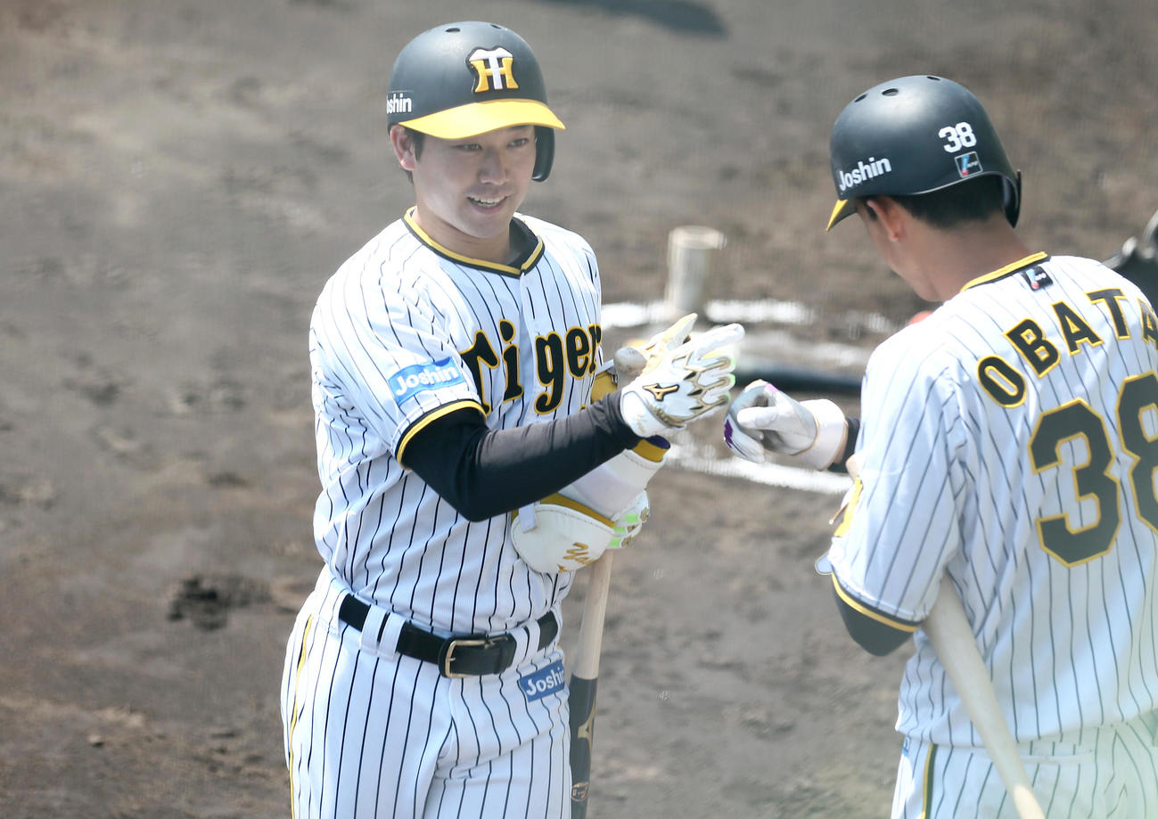 ウエスタン・リーグ阪神対広島　4回裏阪神2死一、二塁、山本（左）は左前適時打を放ち交代となりベンチ前で出迎える小幡とタッチを交わす（撮影・上山淳一）