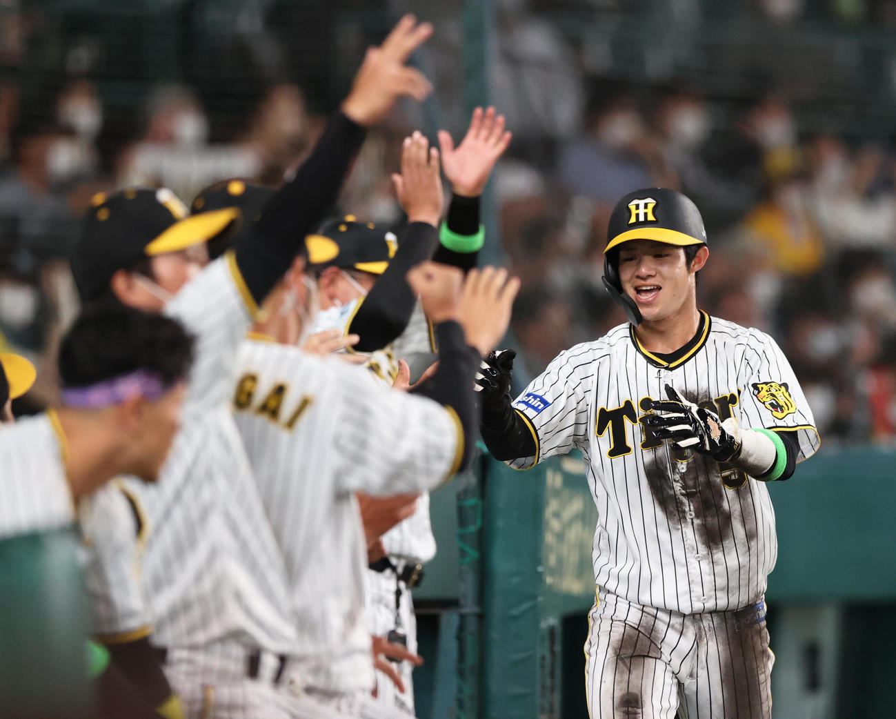 阪神対楽天　6回裏阪神2死二塁、中野（右）は大山の中前適時打で先制生還しナインの出迎えに笑顔を見せる（撮影・上山淳一）