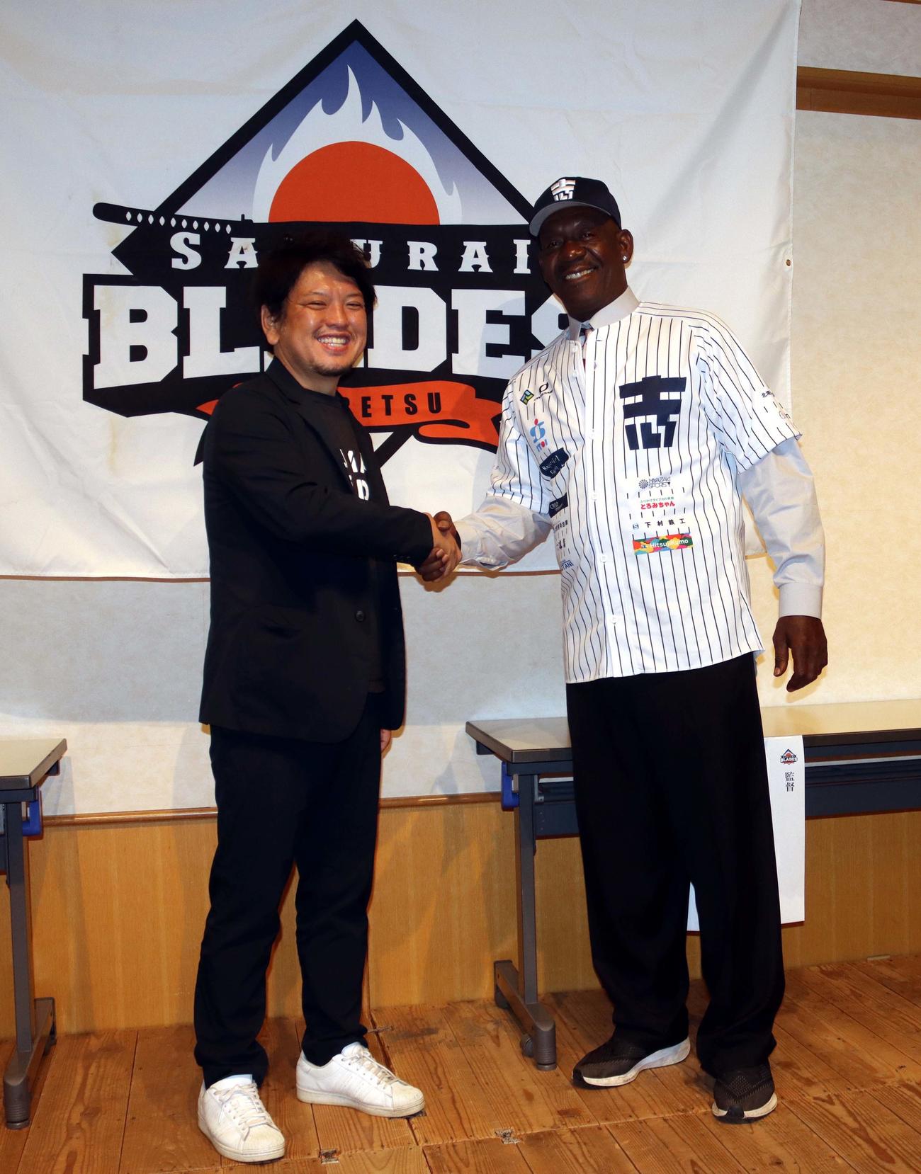 菅原代表（左）と握手をする士別サムライブレイズのブライアント監督