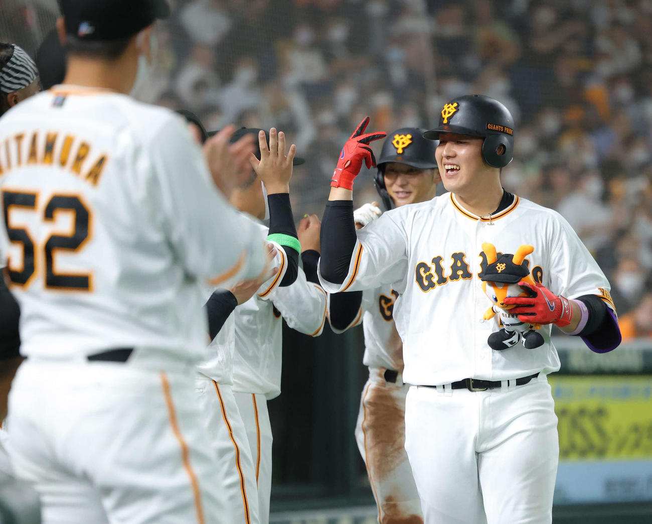 巨人オリックス　4回裏巨人無死一塁、先制2点本塁打で生還しナインに迎えられる岡本和（撮影・河田真司）