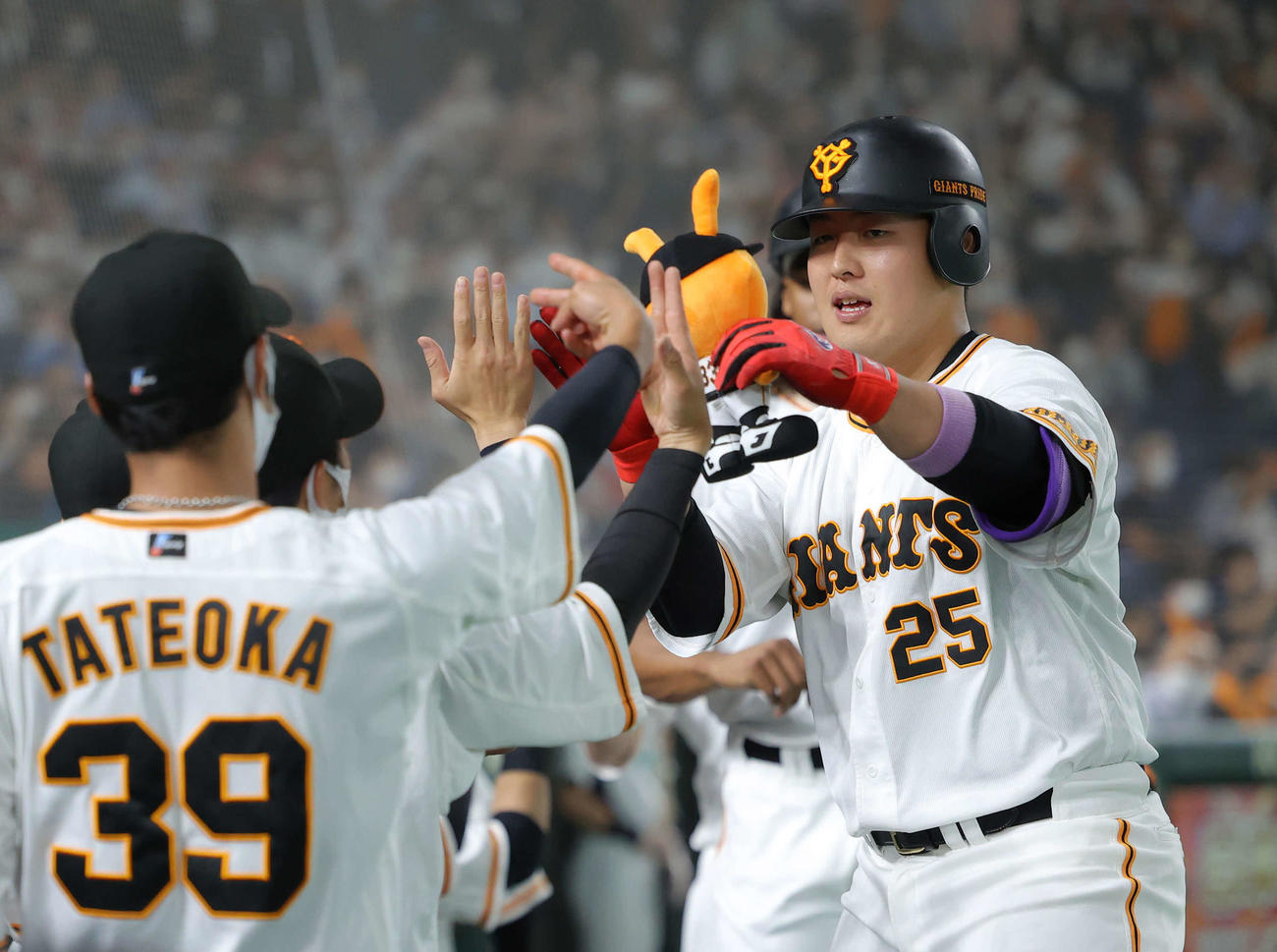 巨人対オリックス　1回裏巨人1死二、三塁、左越え3点本塁打で生還し、ベンチナインに迎えられる岡本和（撮影・河田真司）