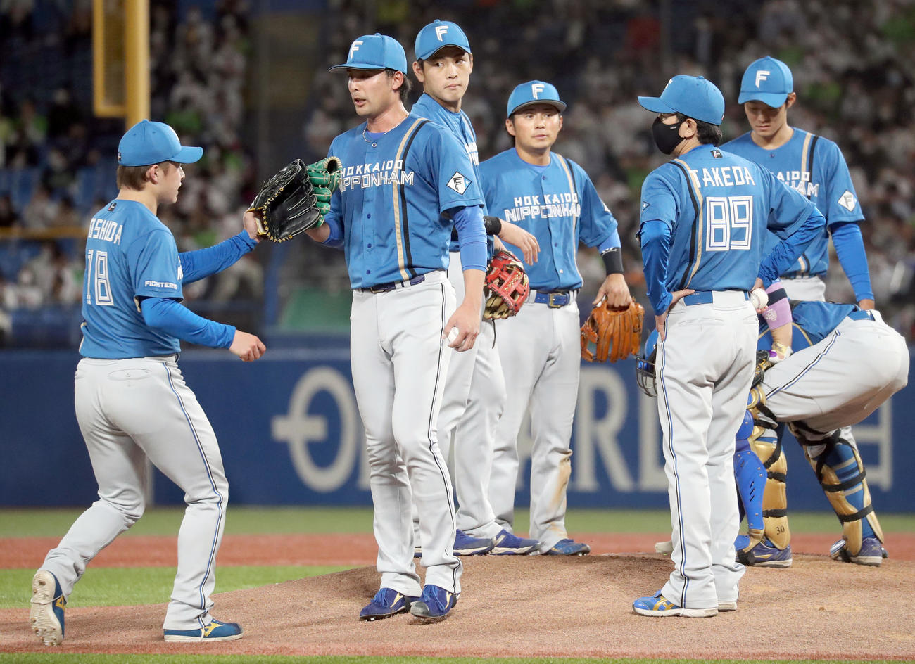 ヤクルト対日本ハム　日本ハム吉田（左）とタッチを交わし降板する上原（撮影・佐藤翔太）