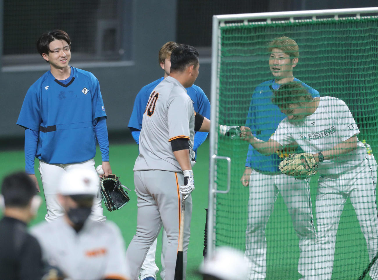 日本ハム対巨人　試合前、巨人中田（手前）にあいさつする日本ハム上沢（左）ら投手陣（撮影・河田真司）
