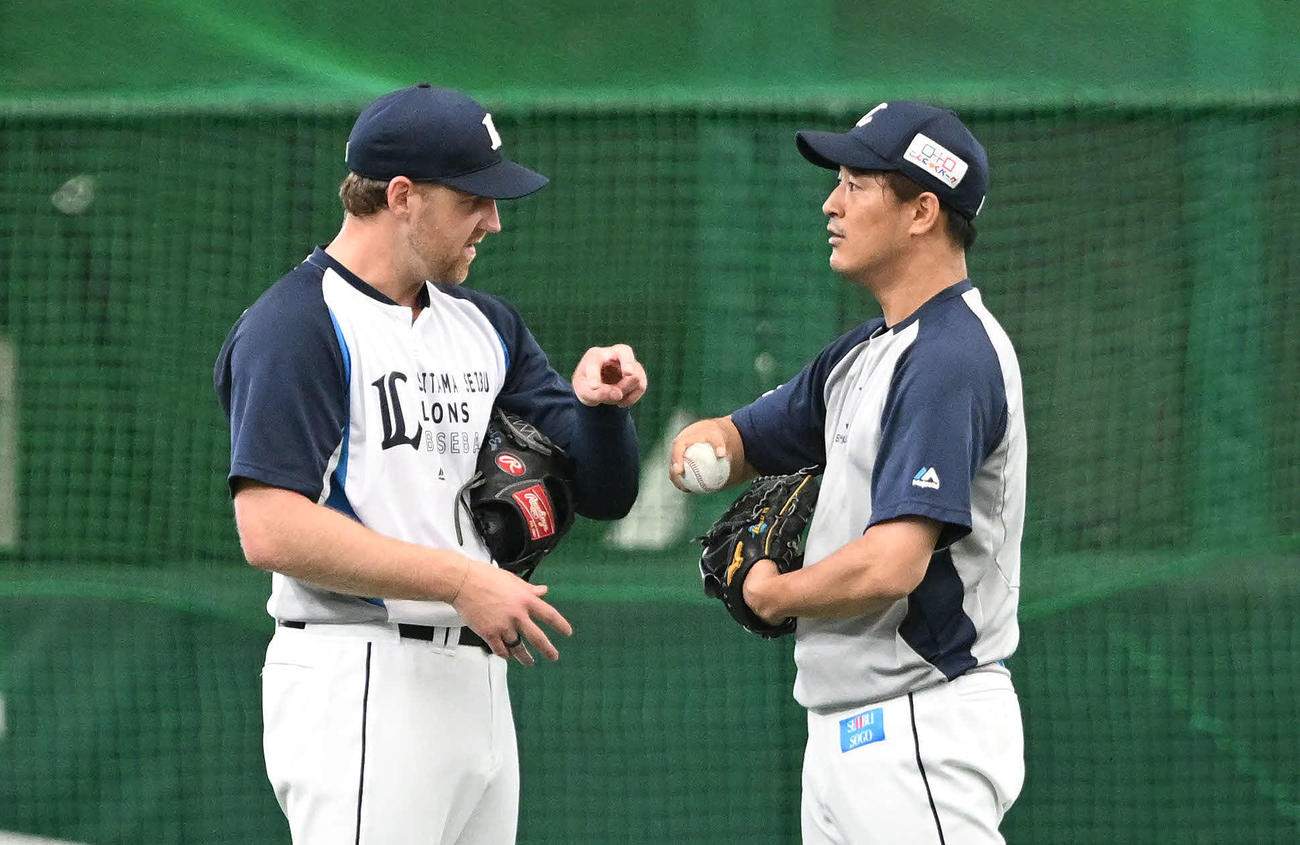 西武対DeNA　試合前練習で西武エンス（左）と握りについて話す平井（撮影・滝沢徹郎）