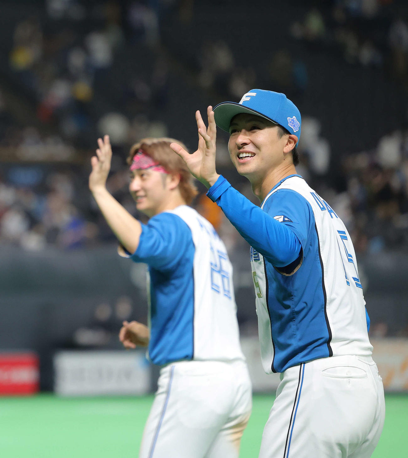 日本ハム対巨人　巨人に勝利し、場内一周しながら観客席に手を振る上沢（手前）と浅間（撮影・河田真司）