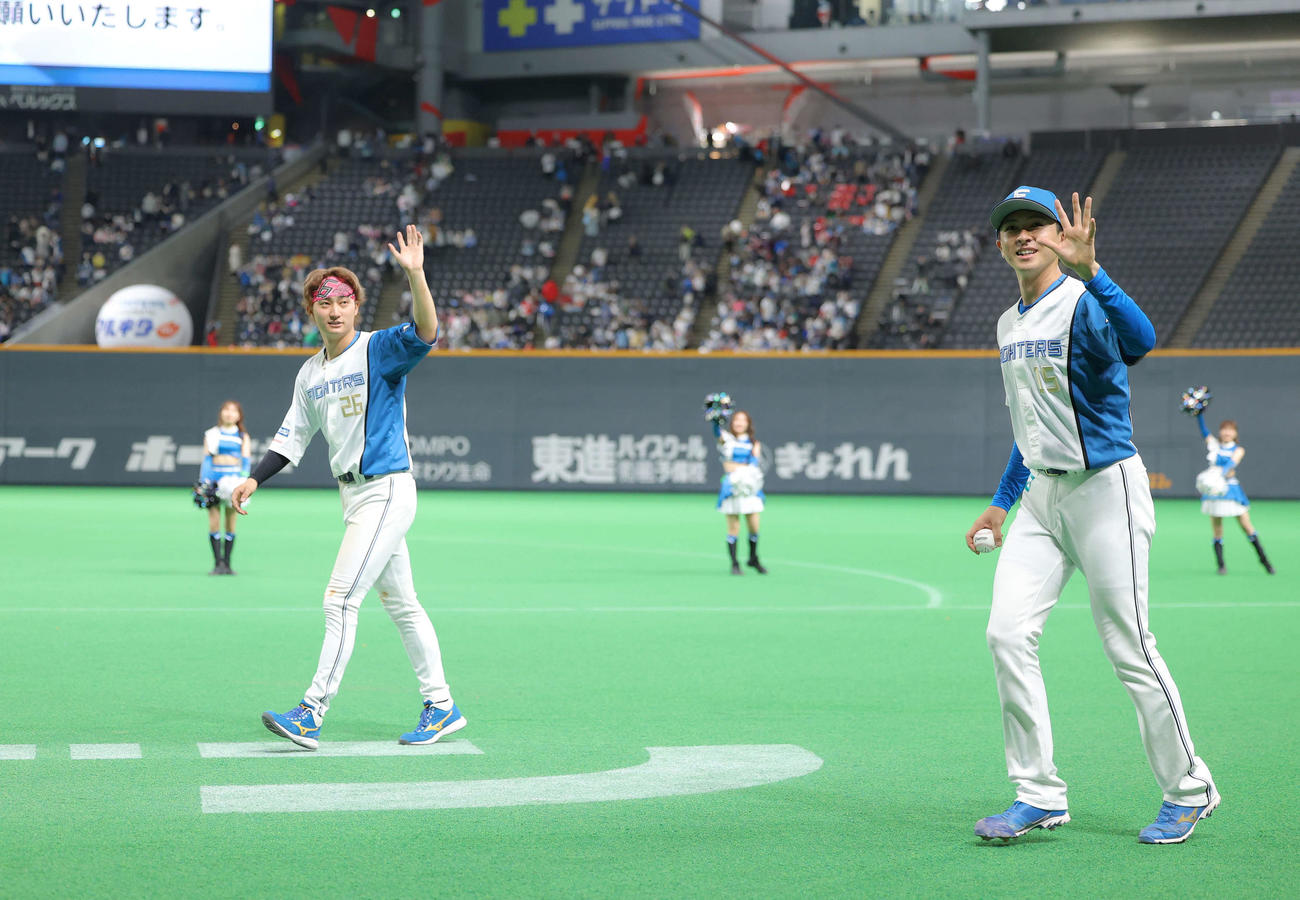 日本ハム対巨人　巨人に勝利し、場内一周しながら観客席に手を振る浅間（左）と上沢（撮影・河田真司）