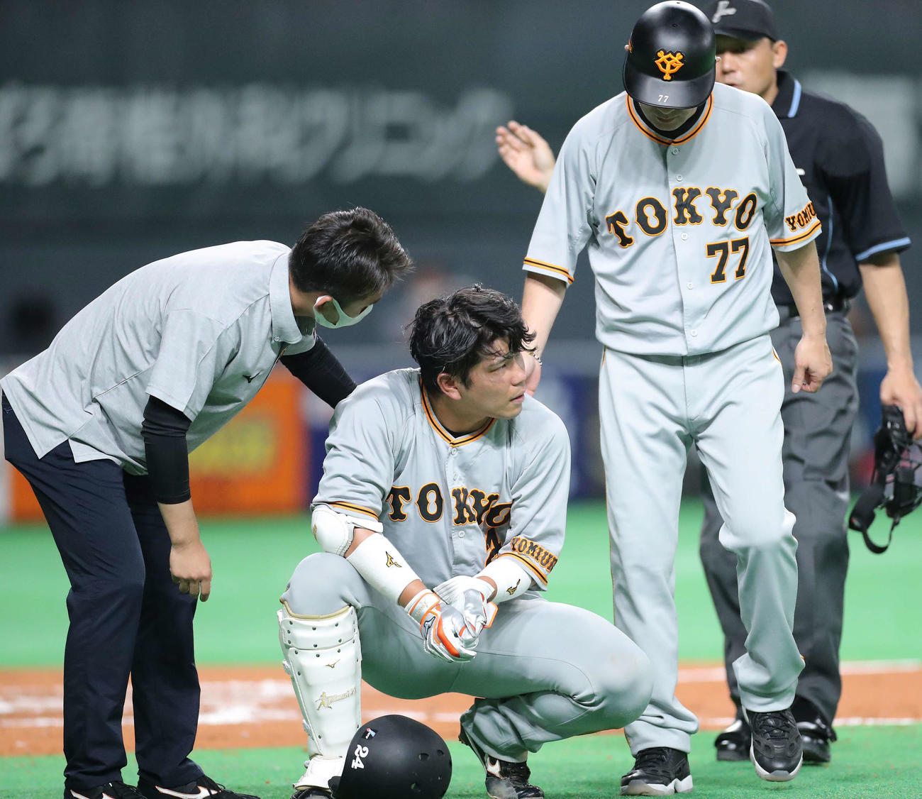 日本ハム対巨人　7回表巨人2死一、二塁、死球を受け、左手を押さえながらしゃがみ込む大城（撮影・河田真司）
