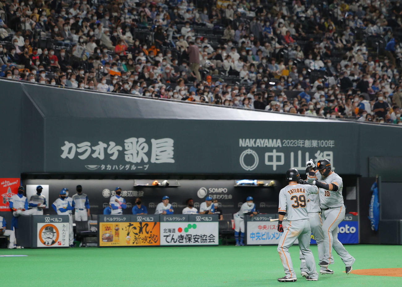 日本ハム対巨人　9回表巨人無死一塁、左越え2点本塁打を放ち生還する中田（右）。後方左は新庄監督（撮影・河田真司）
