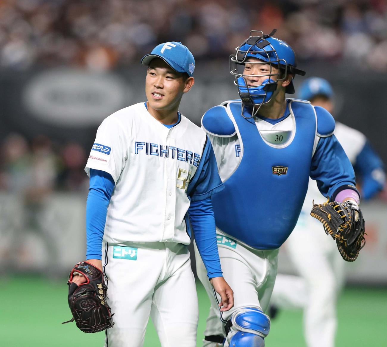 日本ハム対巨人　3回表、無失点に抑え笑顔の根本（左）（撮影・黒川智章）