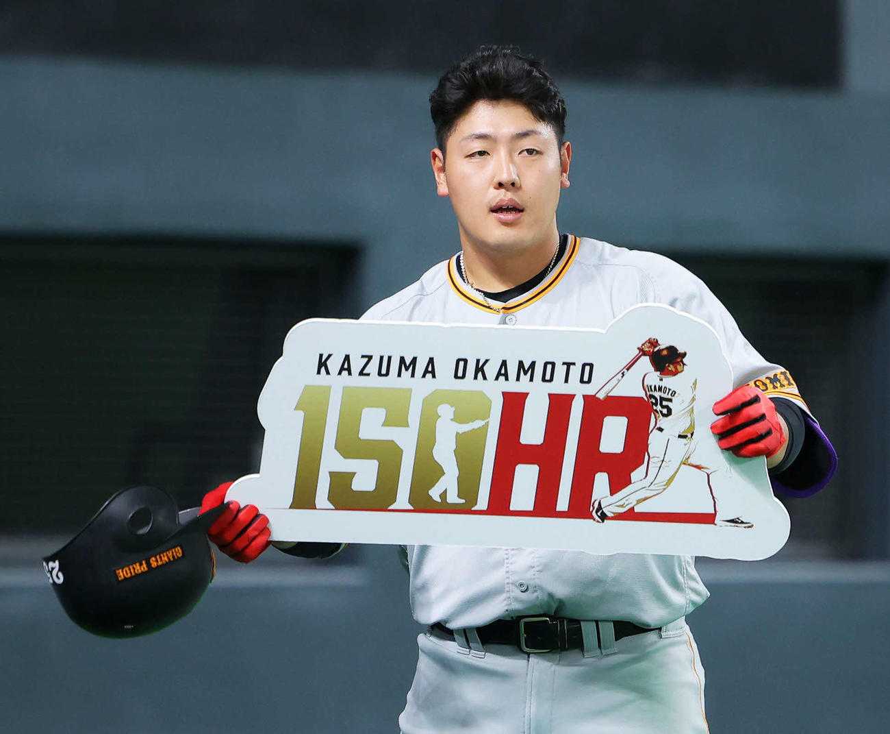 日本ハム対巨人　2回表巨人無死、通算150号本塁打を達成し、ボードを手にあいさつする岡本和（撮影・河田真司）