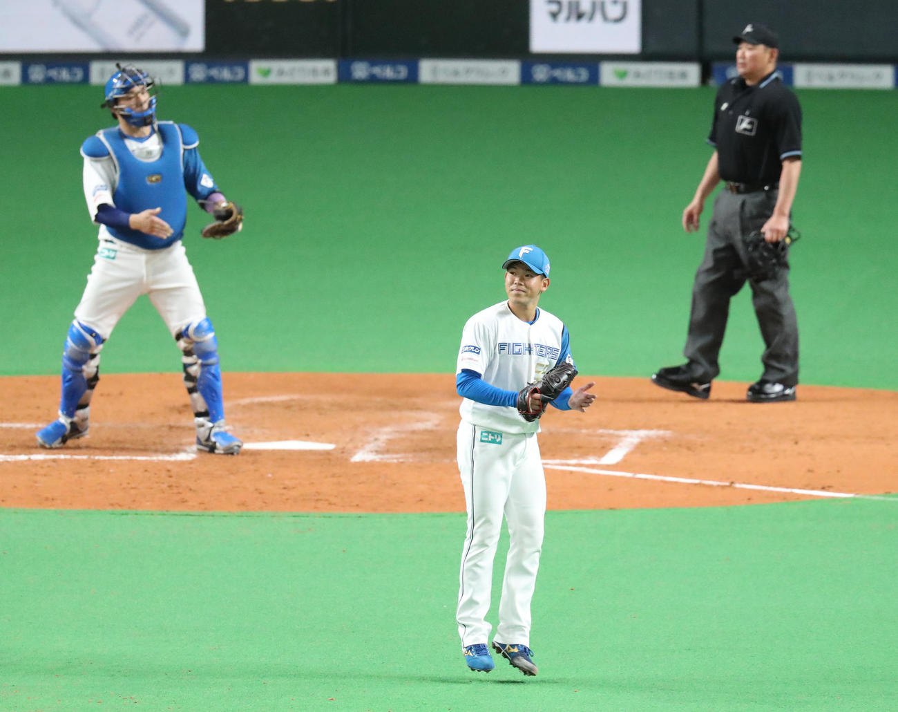日本ハム対巨人　5回表巨人2死一、二塁、吉川を三ゴロに仕留め笑顔でグラブをたたく根本（撮影・佐藤翔太）