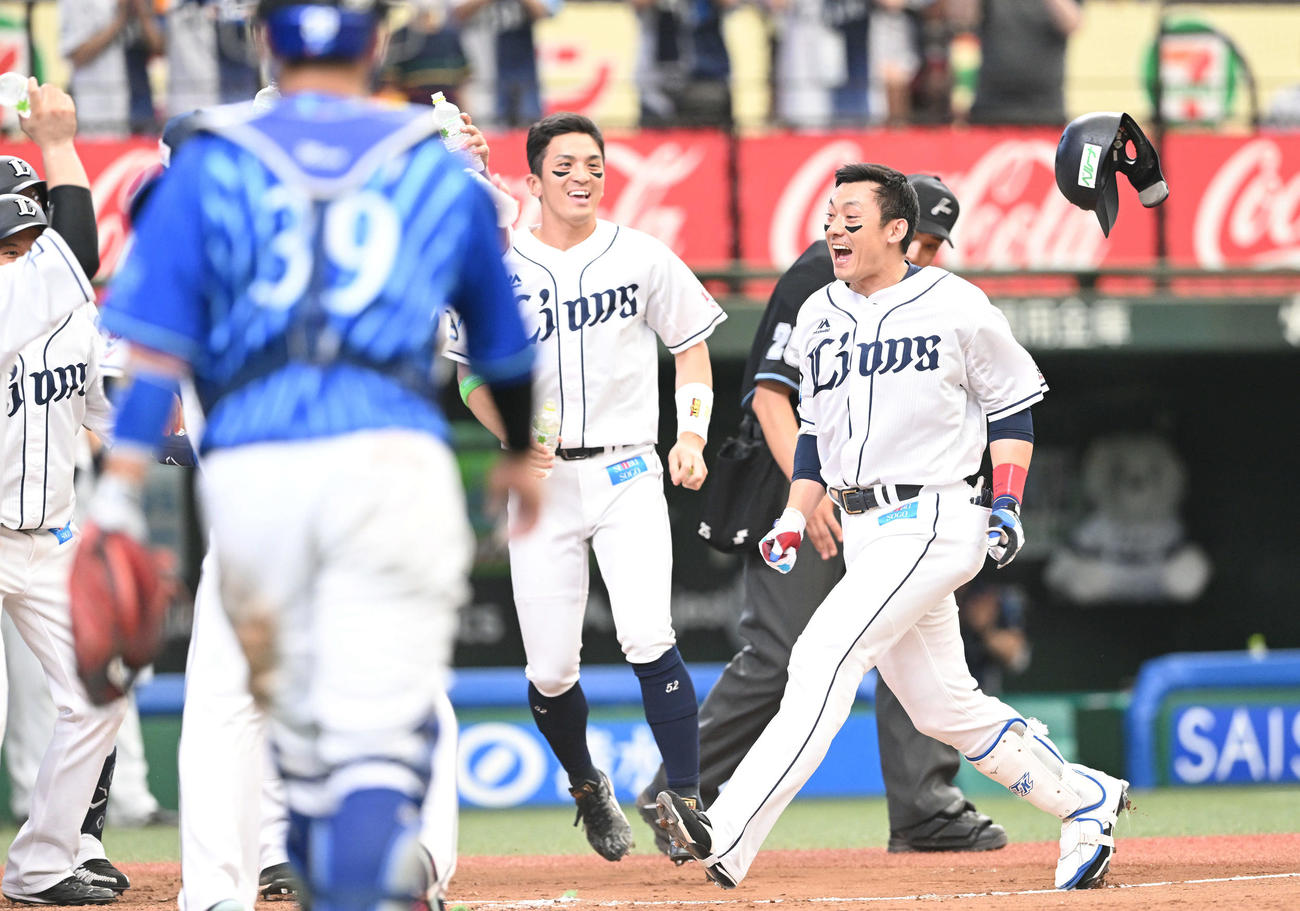 西武対DeNA 9回裏西武無死、サヨナラ本塁打を放った栗山（右）はヘルメットを放り投げナインの待ち受ける本塁へ生還する（撮影・滝沢徹郎）