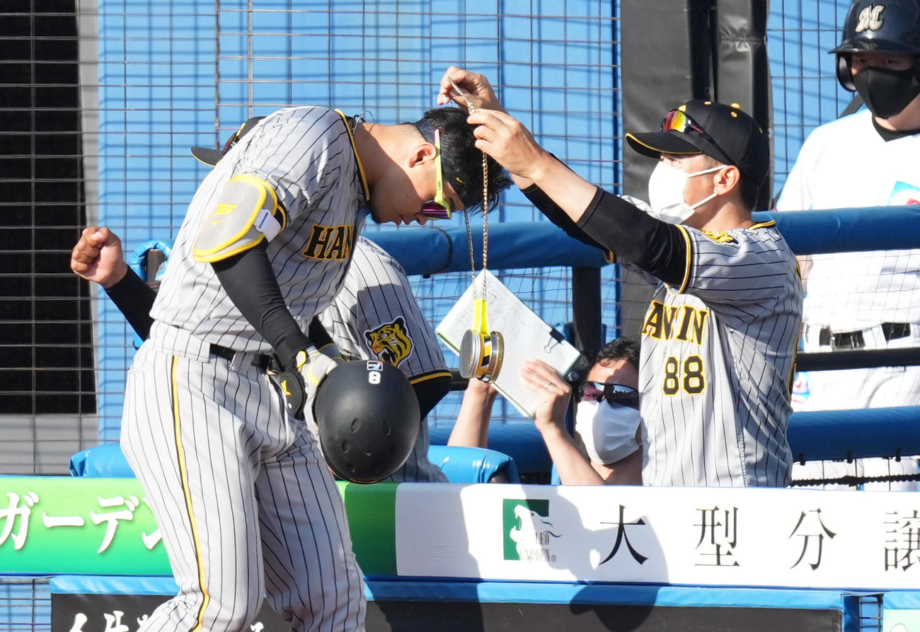 8回表阪神1死二塁、右越えに2点本塁打を放ち、矢野監督（右）からメダルをかけられる佐藤輝（撮影・菅敏）