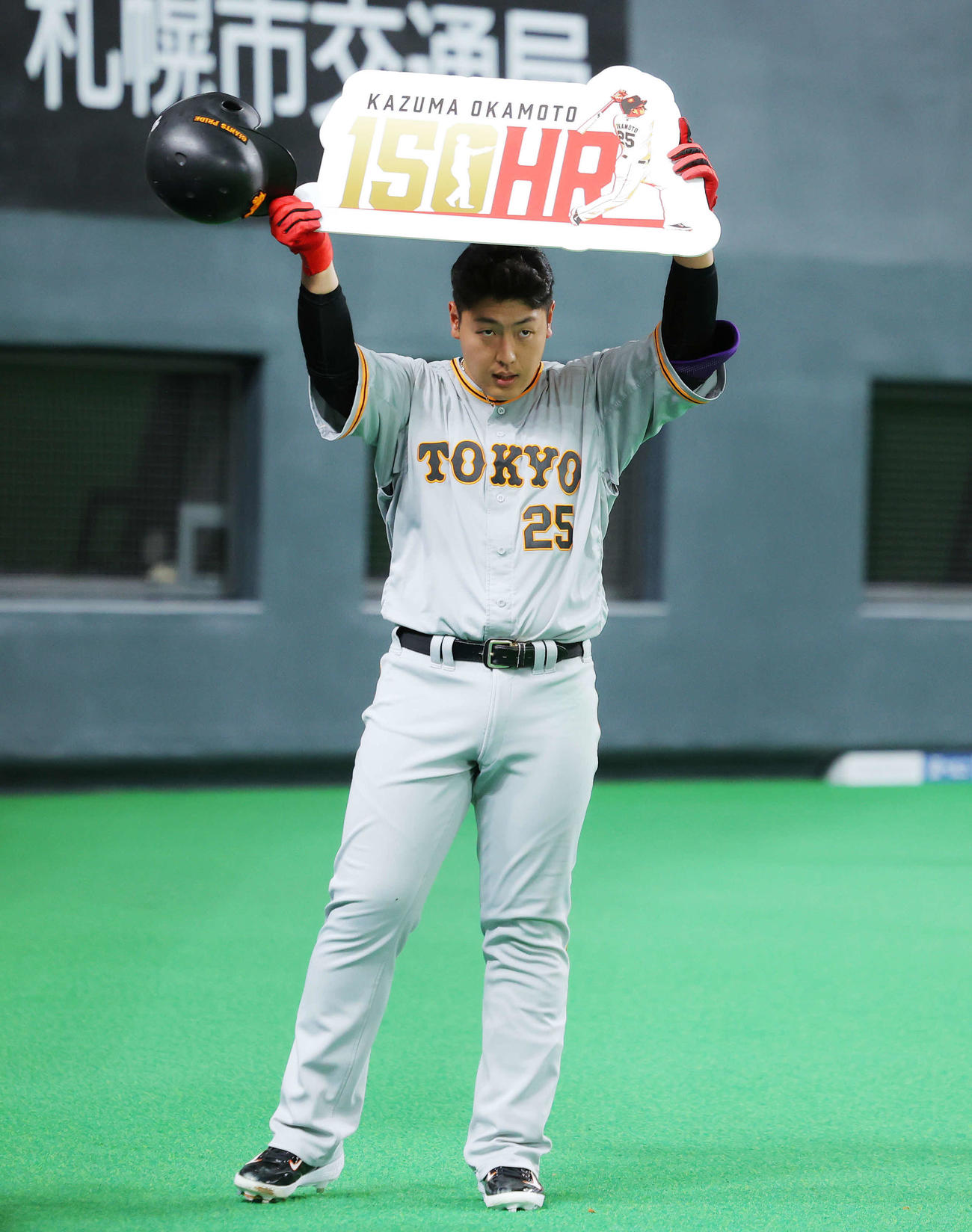 日本ハム対巨人　2回表巨人無死、通算150号本塁打を達成し、ボードを掲げる岡本和（撮影・河田真司）