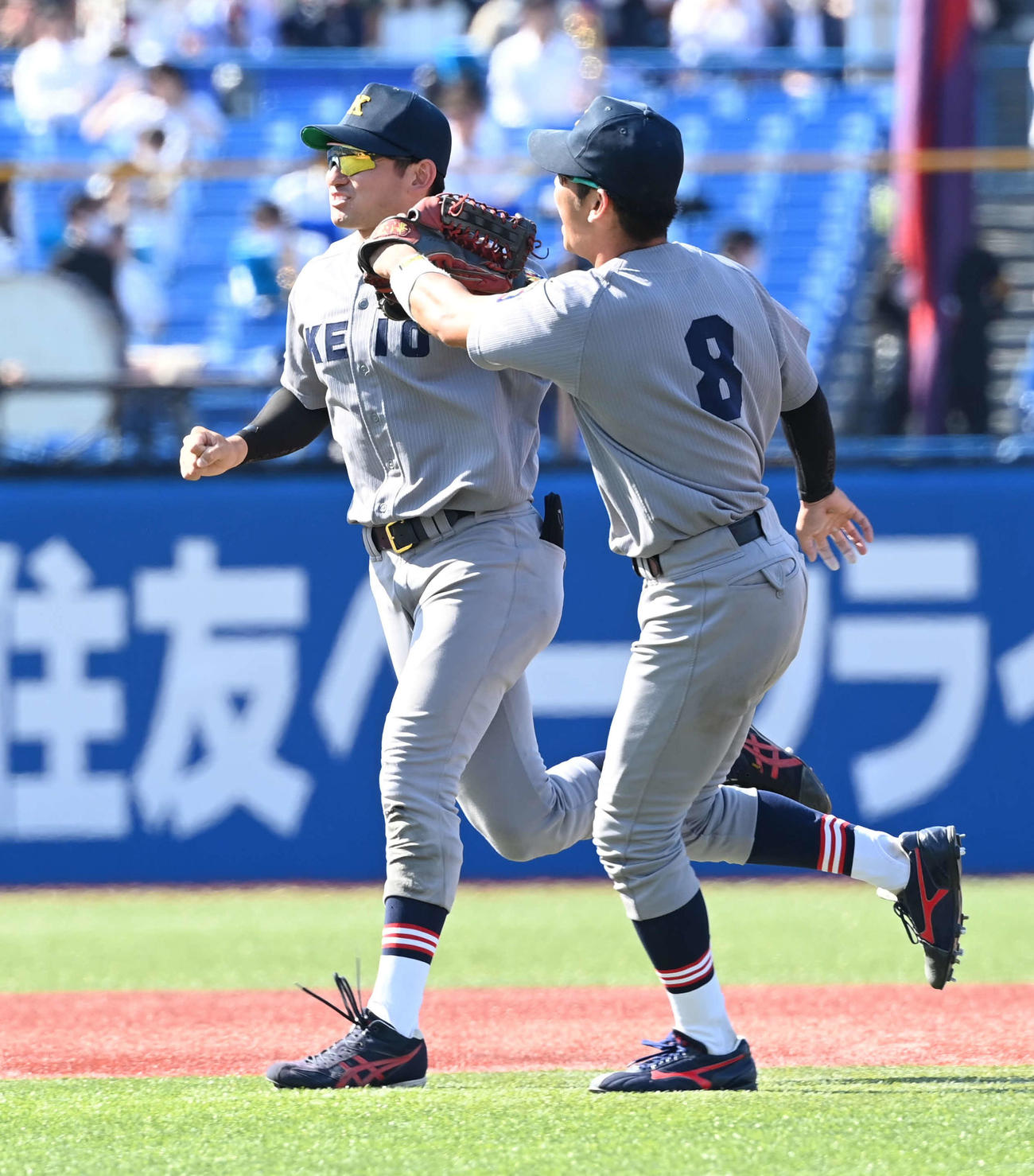 慶大対早大　勝利した慶大・萩尾（左）はチームメートとグラブタッチ（撮影・山崎安昭）