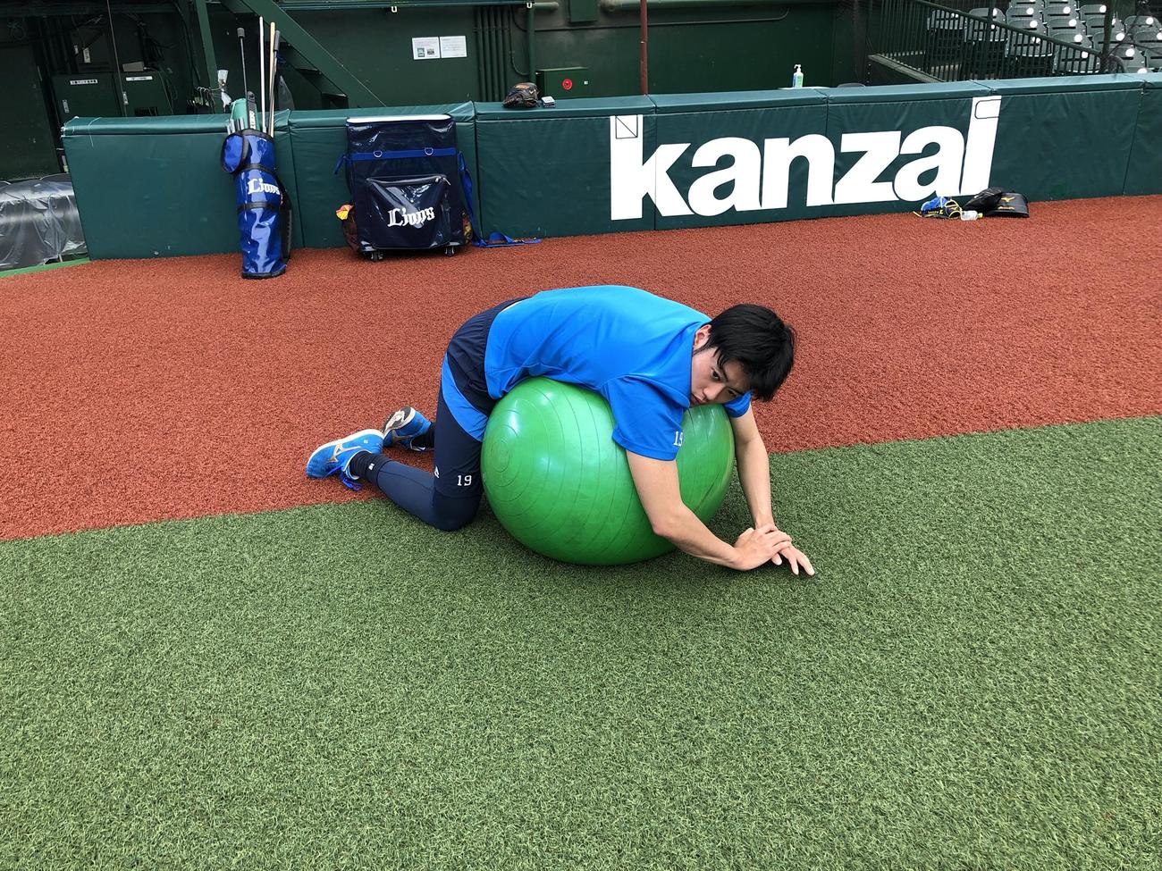 バランスボールでストレッチをする西武佐藤（球団提供）