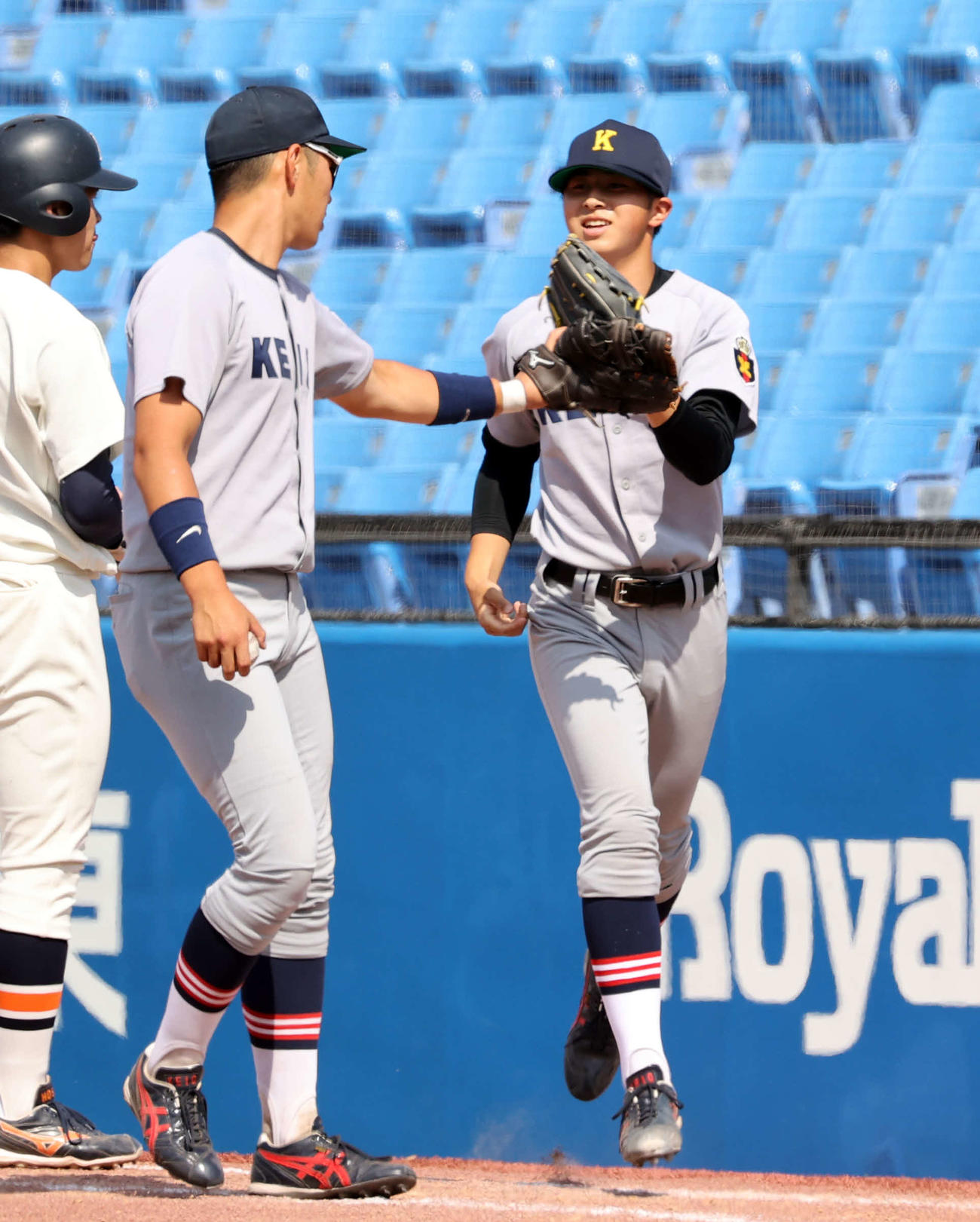 慶大対法大　7回裏法大1死一塁の場面で登板する前田晃（右）は、マウンドに向かいながら一塁手の清原とグラブタッチ（撮影・浅見桂子）