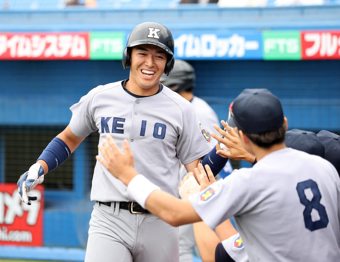 東大対慶大　1回裏慶大2死二塁、森村の左越え適時二塁打で清原が生還しベンチ前で笑顔を見せる（撮影・鈴木正人）