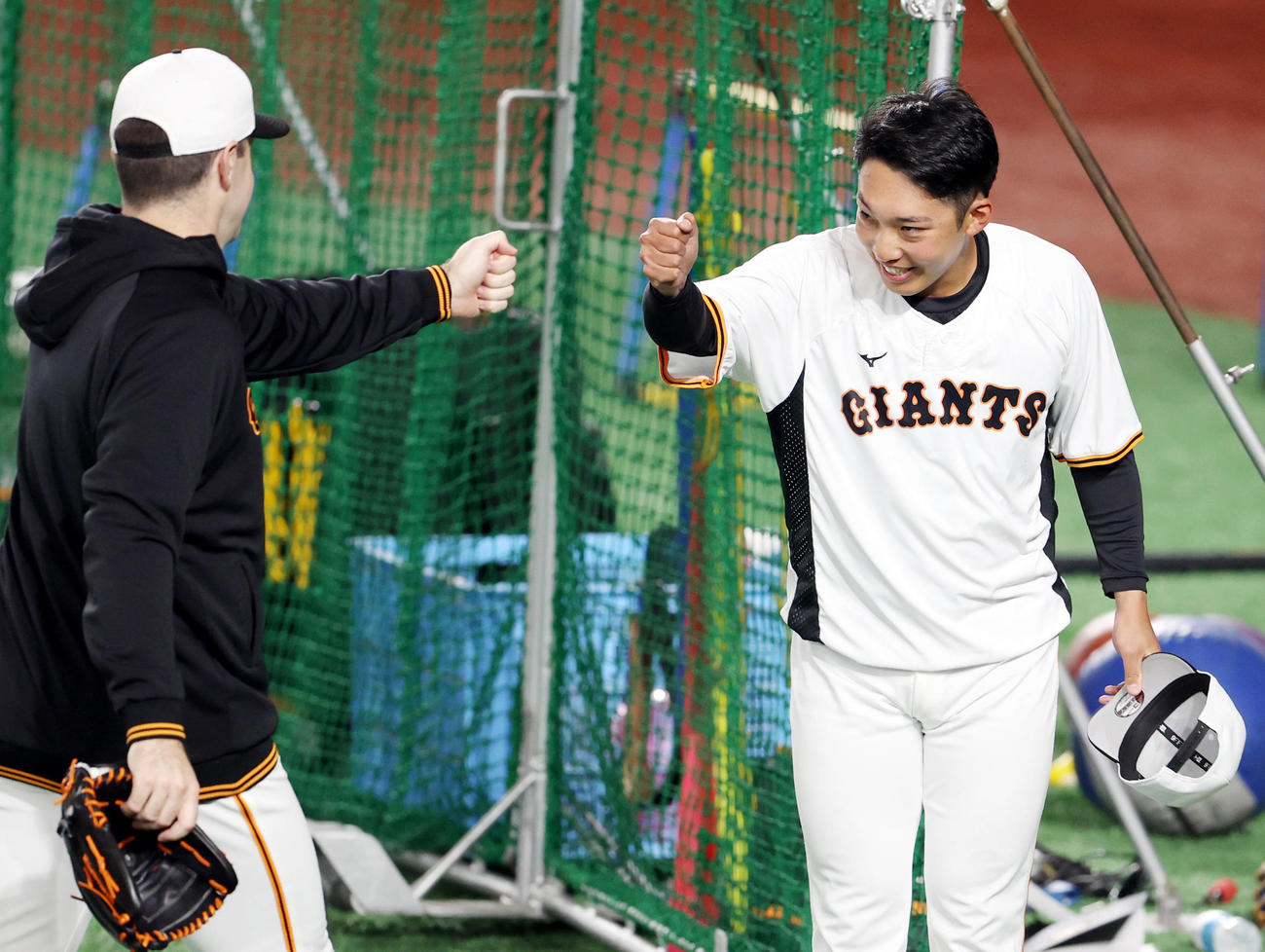 巨人対ソフトバンク　試合前、シューメーカー（左）とタッチを交わす赤星（撮影・狩俣裕三）