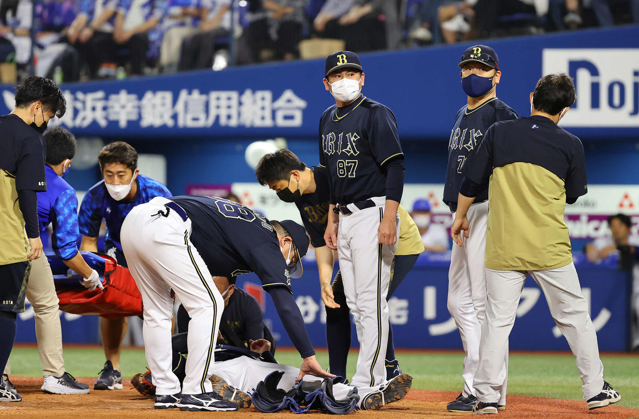 DeNA対オリックス　4回裏DeNA2死一塁、大きく振り切った嶺井のバットが直撃した捕手伏見（下）の様子を心配する中嶋監督（右から2人目）（撮影・垰建太）