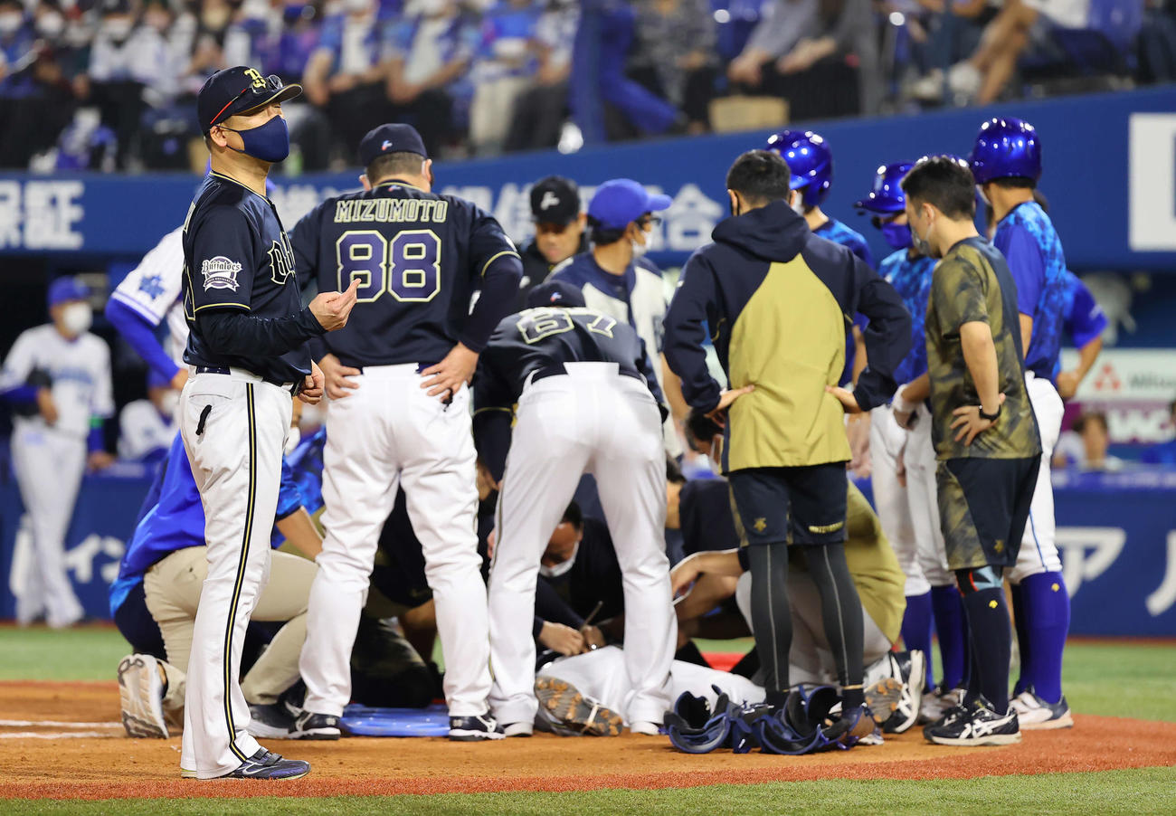 DeNA対オリックス　4回裏DeNA2死一塁、大きく振り切った嶺井のバットが直撃した捕手伏見（下）の様子を心配する中嶋監督（左）（撮影・垰建太）