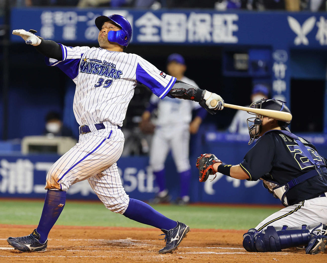 DeNA対オリックス　4回裏DeNA2死一塁、大きく振り切った嶺井のバットが捕手伏見の首もとに直撃する（撮影・垰建太）