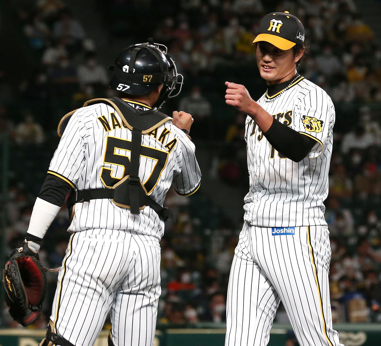 阪神対西武　9回に登板した阪神藤浪（右）は長坂とタッチを交わす（撮影・上山淳一）