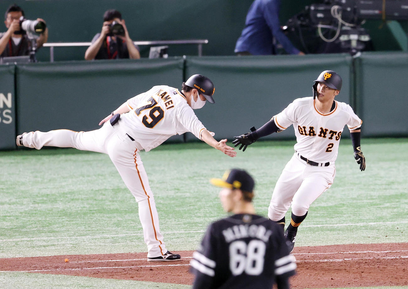 巨人対ソフトバンク　4回裏巨人1死、ソロ本塁打を放ち、亀井外野守備兼走塁コーチ（左）とタッチを交わす吉川（撮影・狩俣裕三）
