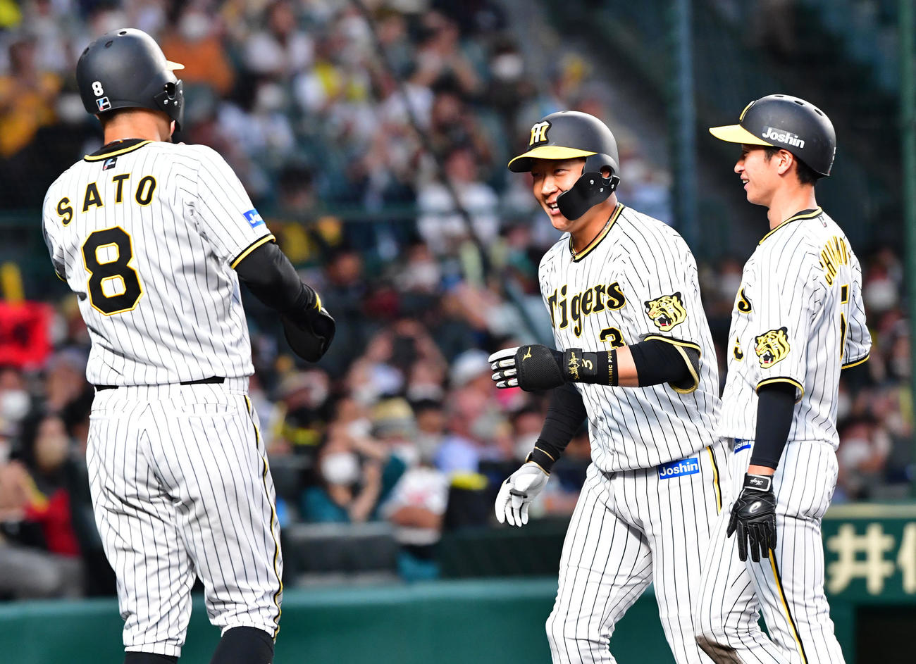 阪神対西武　3回裏阪神1死一、三塁、大山（中央）は左越え3点本塁打を放ち佐藤輝（左）、近本の祝福に笑顔を見せる（撮影・前岡正明）