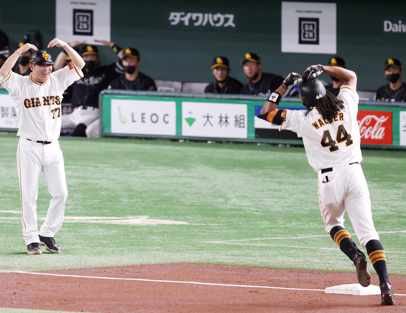 巨人対ソフトバンク　3回裏巨人無死、ソロ本塁打を放ったウォーカー（手前）に合わせ、ハートポーズを決める元木ヘッド兼オフェンスチーフコーチ（左）と松田（後方左）（撮影・狩俣裕三）