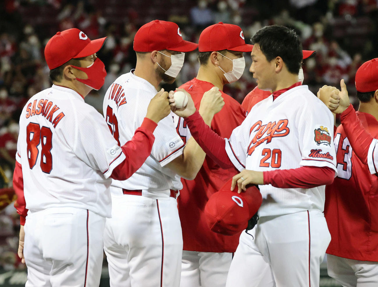 交流戦広島対日本ハム　佐々岡監督（左）とグータッチする栗林（撮影・加藤孝規）